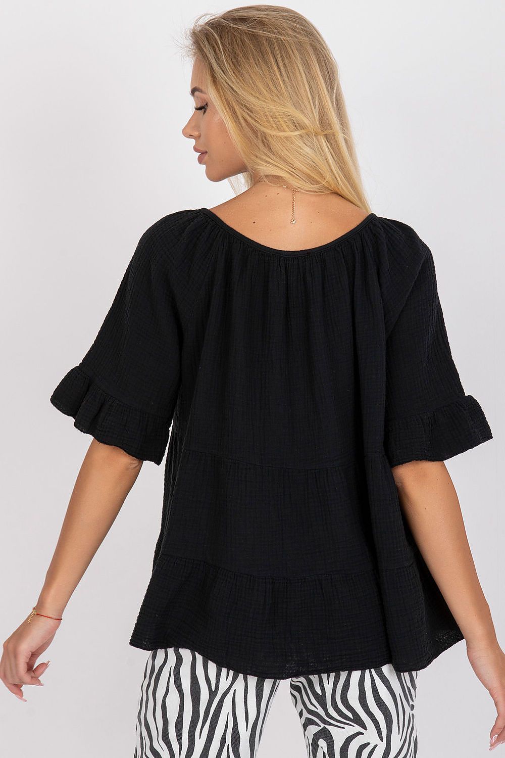 Stylish back view of a black loose fit cotton blouse with ruffled sleeves, highlighting its delicate construction and everyday elegance.