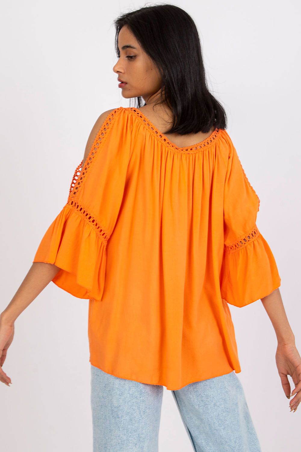 Chic back view of a striking ochre loose-fit blouse with 3/4 sleeves and decorative slits, ideal for a luxurious yet casual outfit.