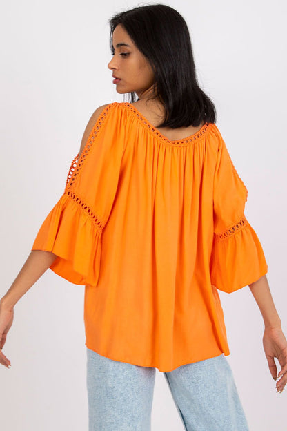 Chic back view of a striking ochre loose-fit blouse with 3/4 sleeves and decorative slits, ideal for a luxurious yet casual outfit.