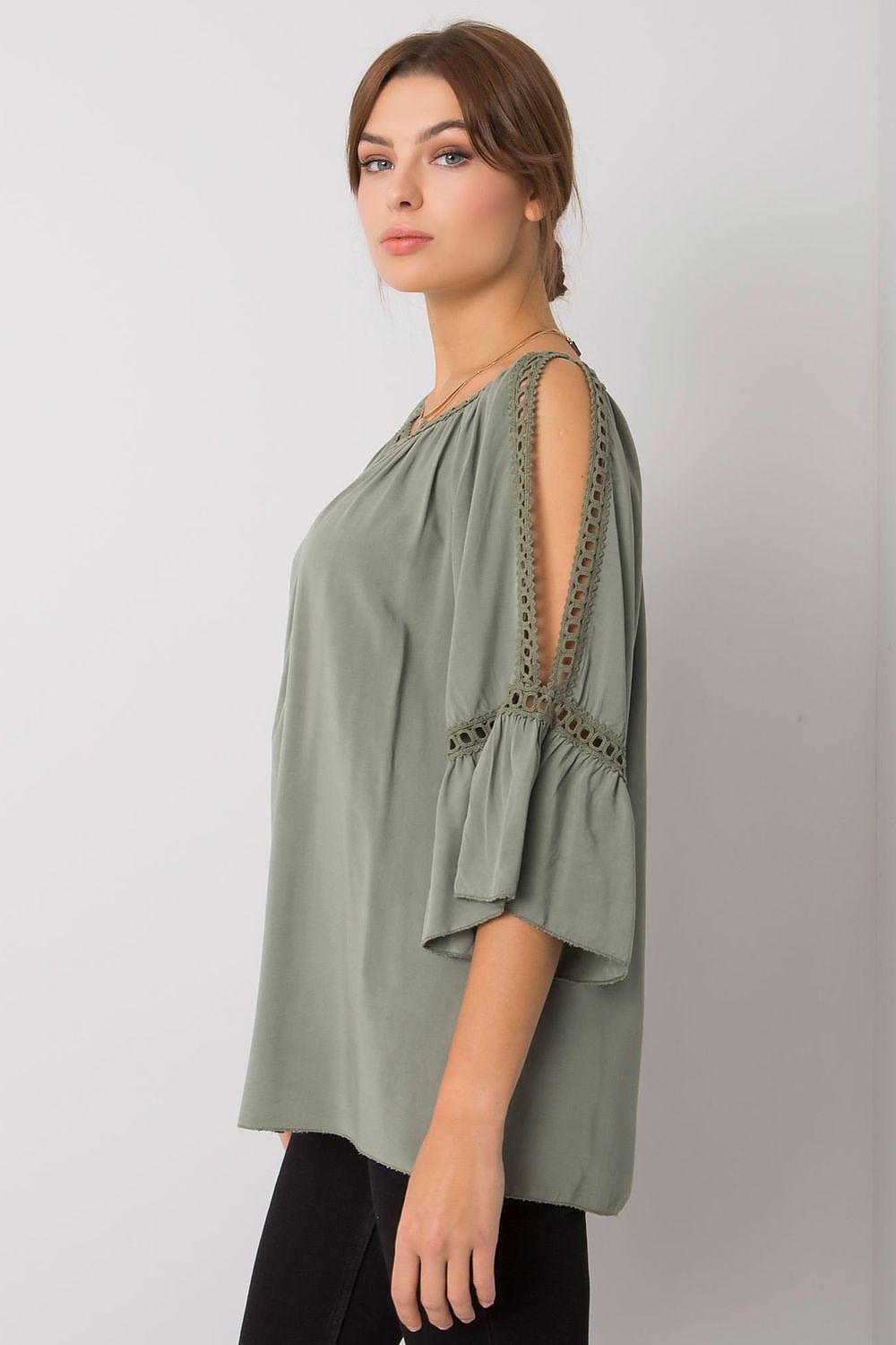 Stylish side view of an olive green, loose-fit blouse featuring 3/4 sleeves and exquisite slit accents, exuding a luxurious feel.