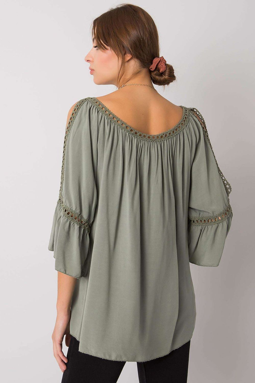 Elegant loose-fit viscose blouse featuring a delicate open back design and 3/4 sleeves with intricate decorative details, styled for a sophisticated look.