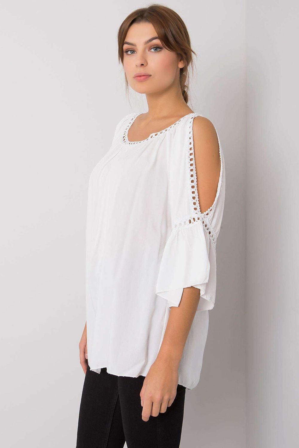Stylish side view of a luxurious white loose-fit blouse showcasing soft draping and exquisite decorative openings on the sleeves accessorised with elegant black trousers.
