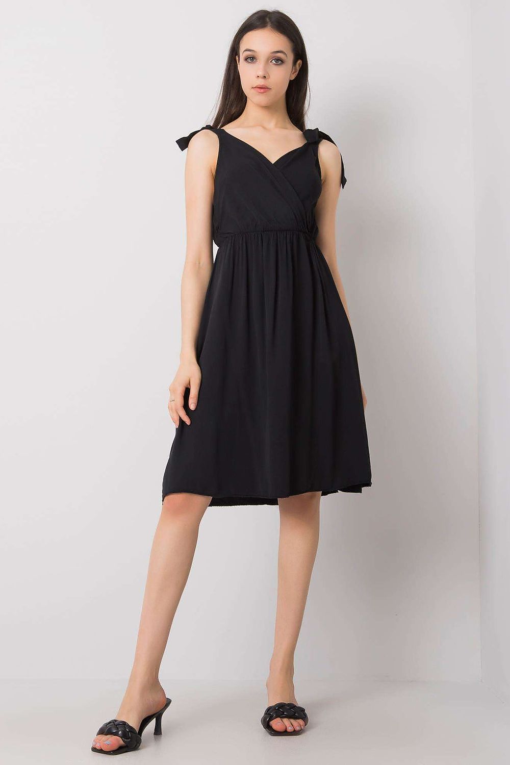 Chic ochre sleeveless daydress by Och Bella, in timeless black, designed with a flattering envelope neckline and feminine tie straps, ideal for summer elegance.