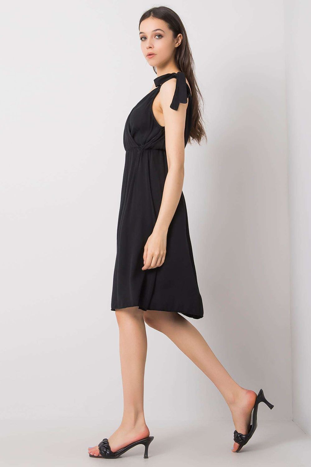 Side profile of a stunning black sleeveless daydress from Och Bella, emphasising the graceful design with tie straps, suitable for various summer events.