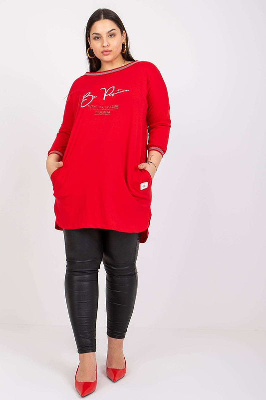 Luxury red tunic with 3/4 sleeves and a decorative inscription, styled with slim black leather leggings and red pointed heels, perfect for sophisticated casual wear.