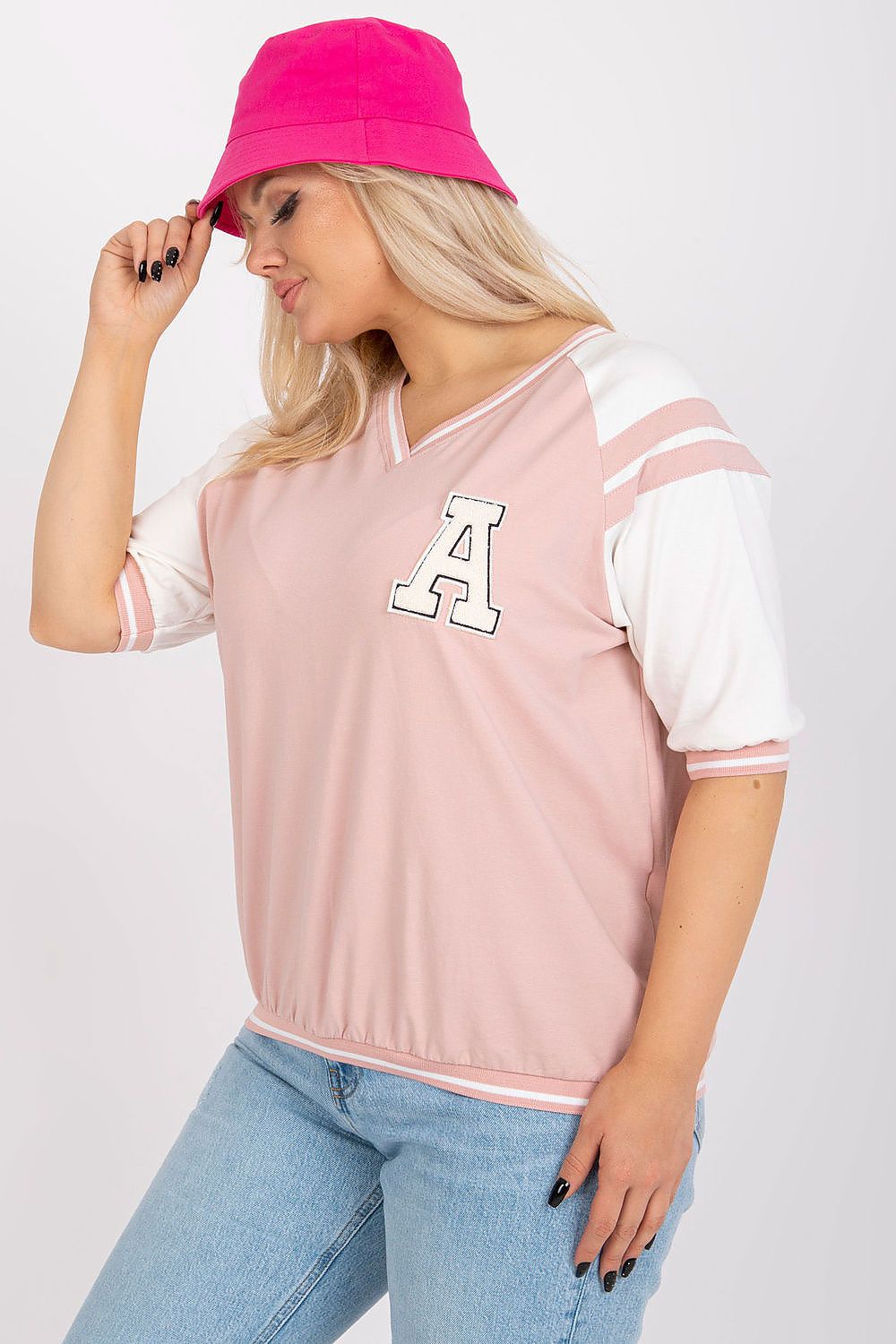 Chic model wearing a rose pink oversized blouse with a letter 'A' patch and a stylish pink bucket hat, perfect for a trendy casual look.