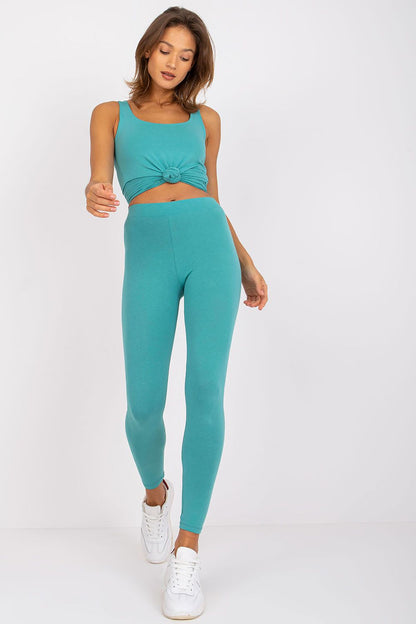 Graceful model stepping forward in BFG Luxury Cotton-Spandex Leggings paired with a teal knotted tank top, reflecting a sophisticated and effortless style perfect for any occasion.