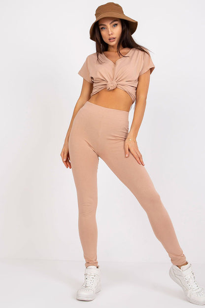 Stylish model wearing BFG Luxury Cotton-Spandex Leggings in nude, paired with a knotted top and a trendy hat, representing sophisticated leisure wear.