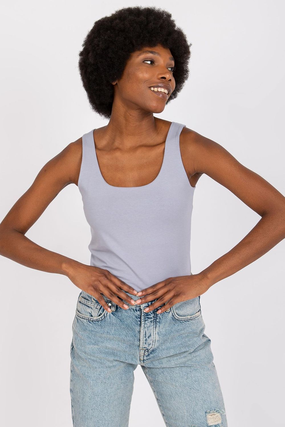 Stylish Strapless T-Shirt for Summer – Comfortable Cotton Blend, Multiple Sizes Available, showcased by a model with an elegant afro hairstyle, wearing a light grey tank top and denim jeans, perfect for a chic summer outing.