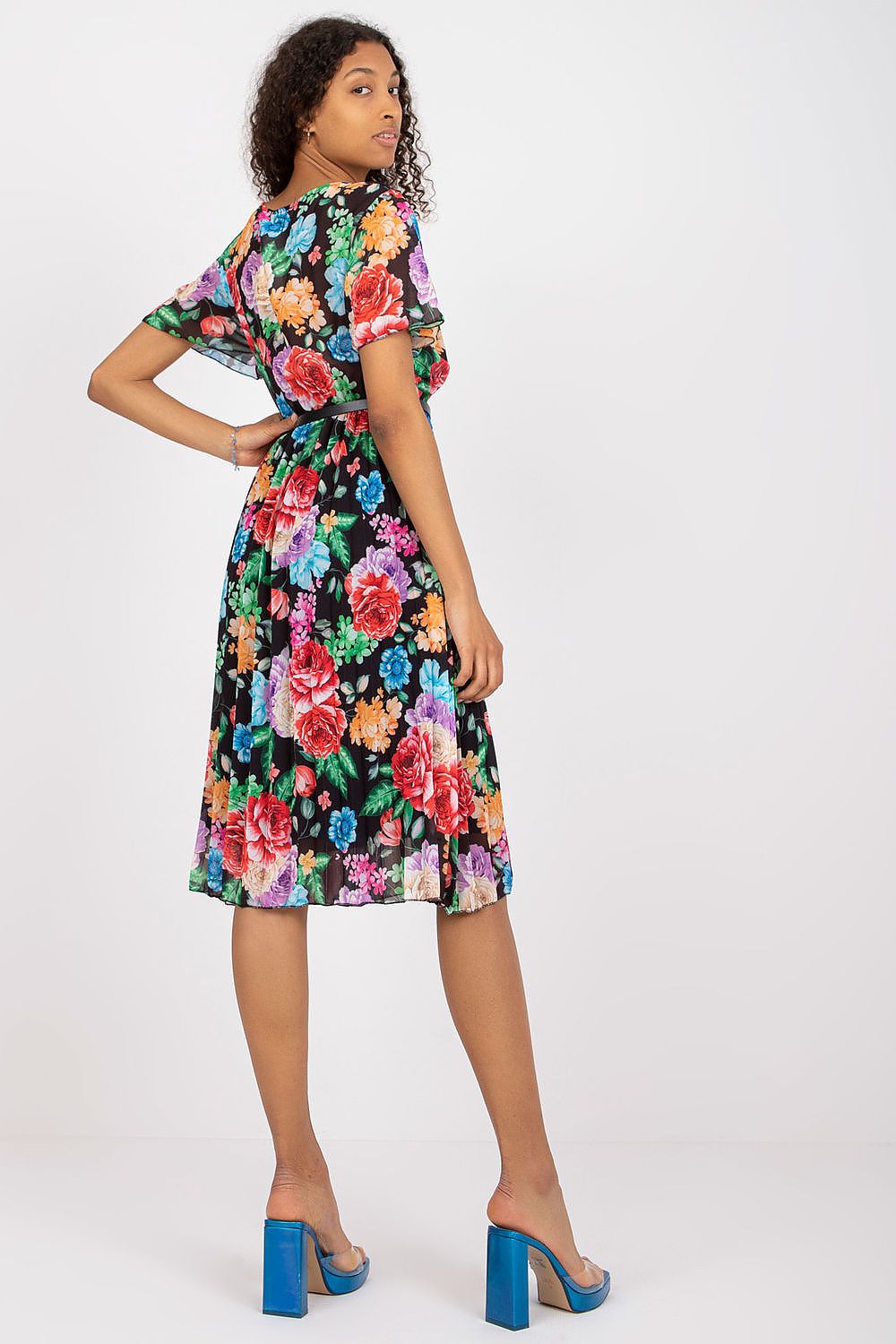 Stylish floral summer dress with belt and pleated hem by Italy Moda, showcasing model in a luxurious floral pattern on a black background.