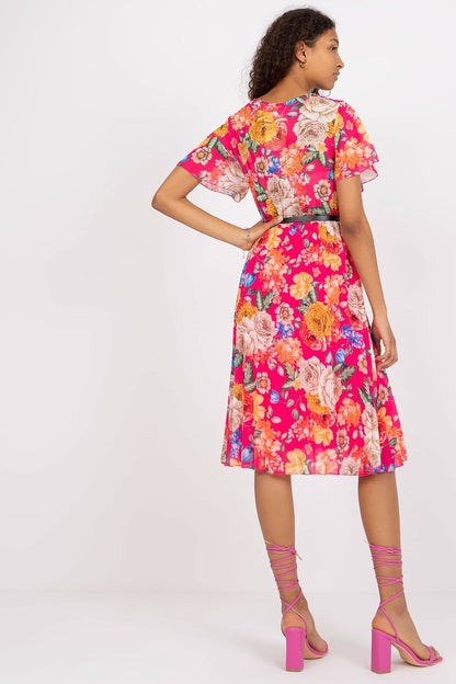 Floral Summer Dress with Belt and Pleated Hem by Italy Moda - Elegant Flared Design. The back view of the model highlights the exquisite details of the pleated hem on the vibrant pink floral dress with a stylish belt.