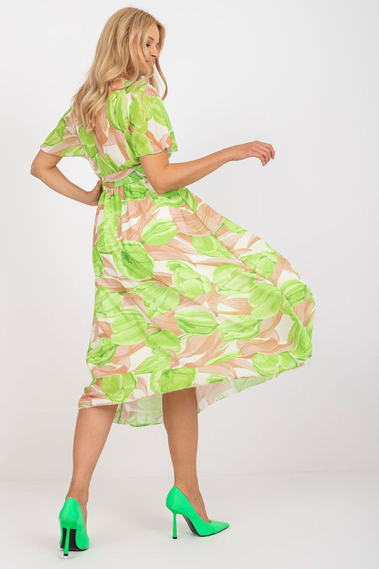 Elegant Summer Dress with Short Frilled Sleeves and Belted Waist by Italy Moda featuring a model twirling in a vibrant green floral print, showcasing the flared bottom and exquisite styling.