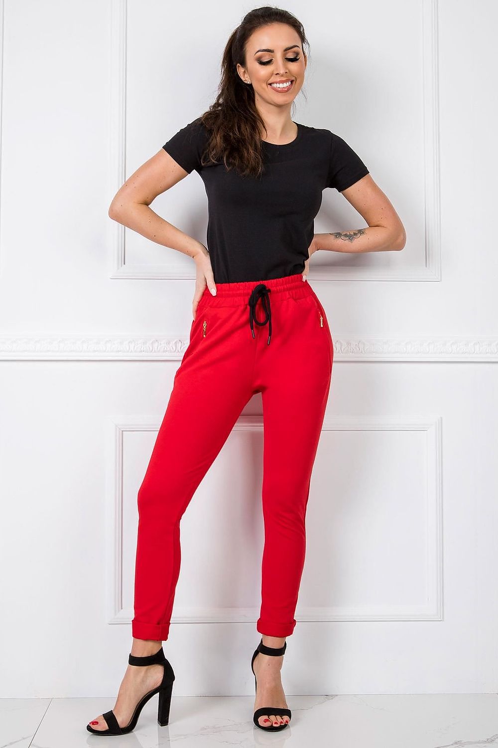 BFG Women’s High-Waisted Slim Leg Tracksuit Trousers in bold red, perfectly fitted to accentuate elegance with luxurious detailing, paired with high heels.
