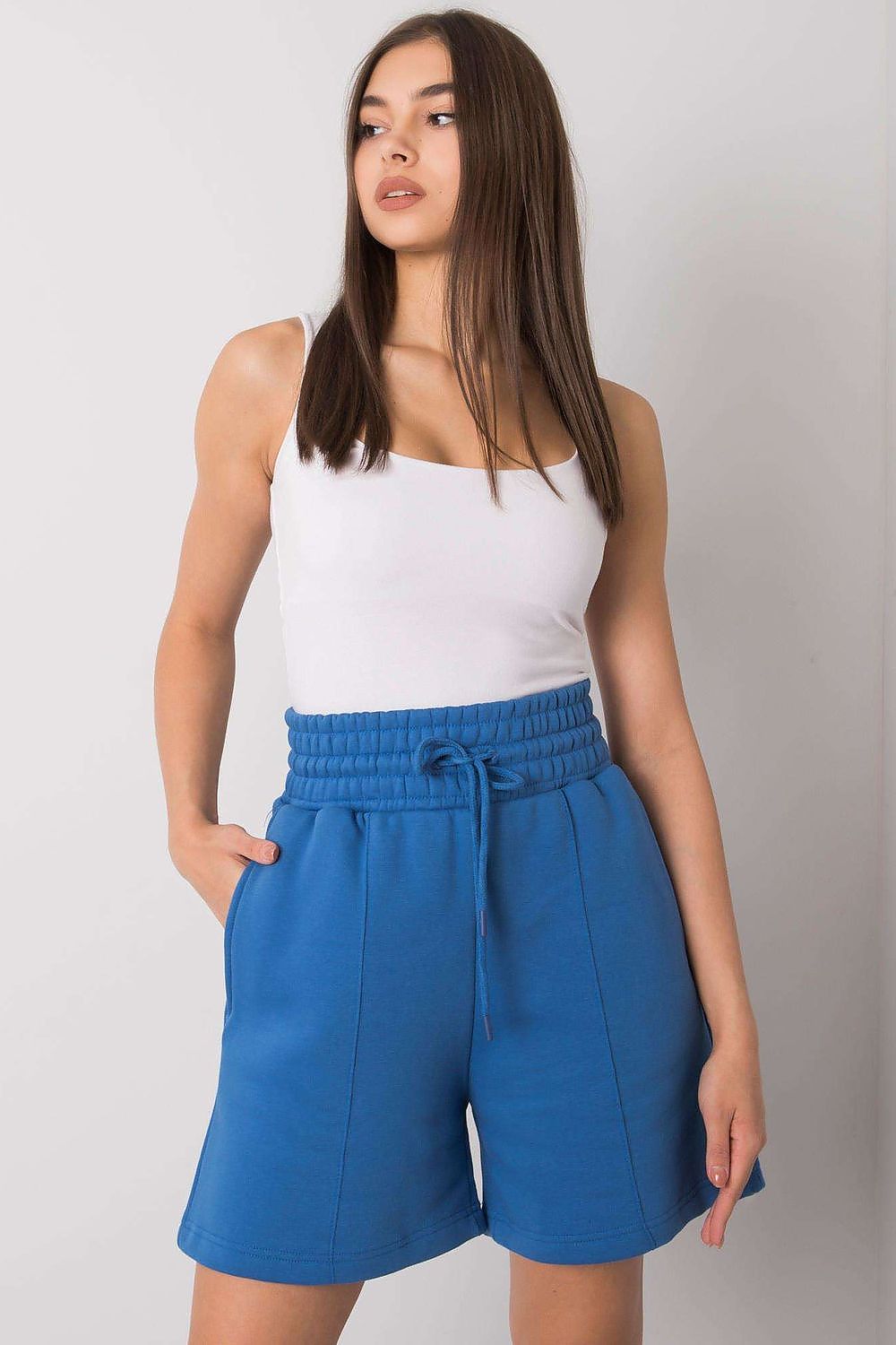 Elegant Cotton Women's Shorts with Elastic Waistband and Slip-On Pockets by BFG, model showcasing stylish blue shorts paired with a fitted white tank top, highlighting the comfortable elastic waistband.
