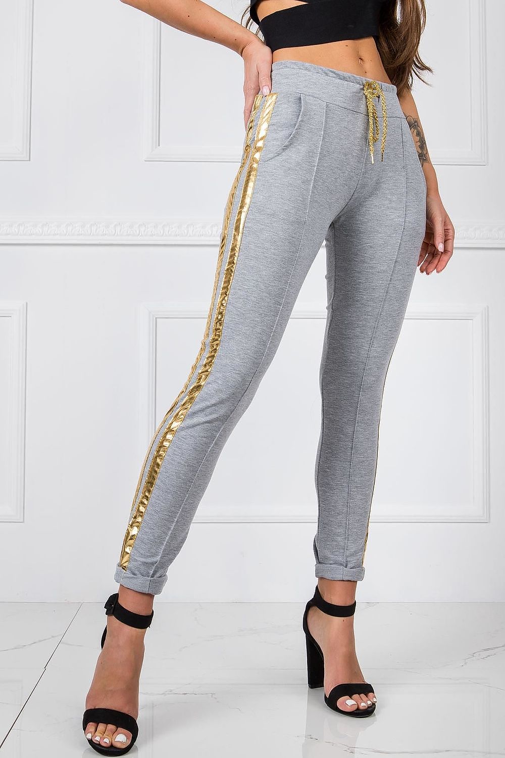 Luxury Women's Tracksuit Trousers with Elastic Waistband and Contrasting Side Stripes, model showcasing stylish grey tracksuit trousers with gold side stripes, paired with high heels.