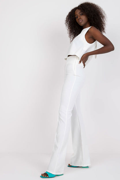 Elegant Italy Moda Blouse and Long Pants Set - Sleeveless Tie-Back Design, High Waist Trousers. Model showcasing the stylish white set with flared trousers, embodying sophistication.