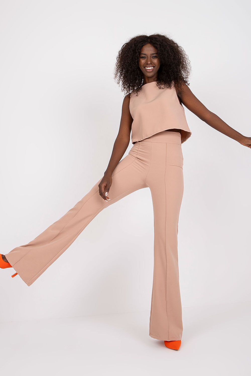 Elegant Italy Moda Blouse and Long Pants Set showcased with a playful pose, highlighting the sleeveless tie-back design and flared high waist trousers.