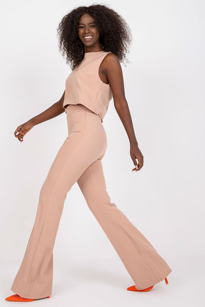Elegant Italy Moda Blouse and Long Pants Set, model walking gracefully in a sophisticated look, featuring a sleeveless tie-back blouse and high waist trousers.