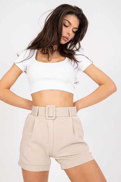 Elegant Women's Italy Moda Shorts With Zip Closure, Side Pockets & Matching Belt - Model showcasing elegant beige shorts with matching belt, styled with a white crop top for a sophisticated appearance.