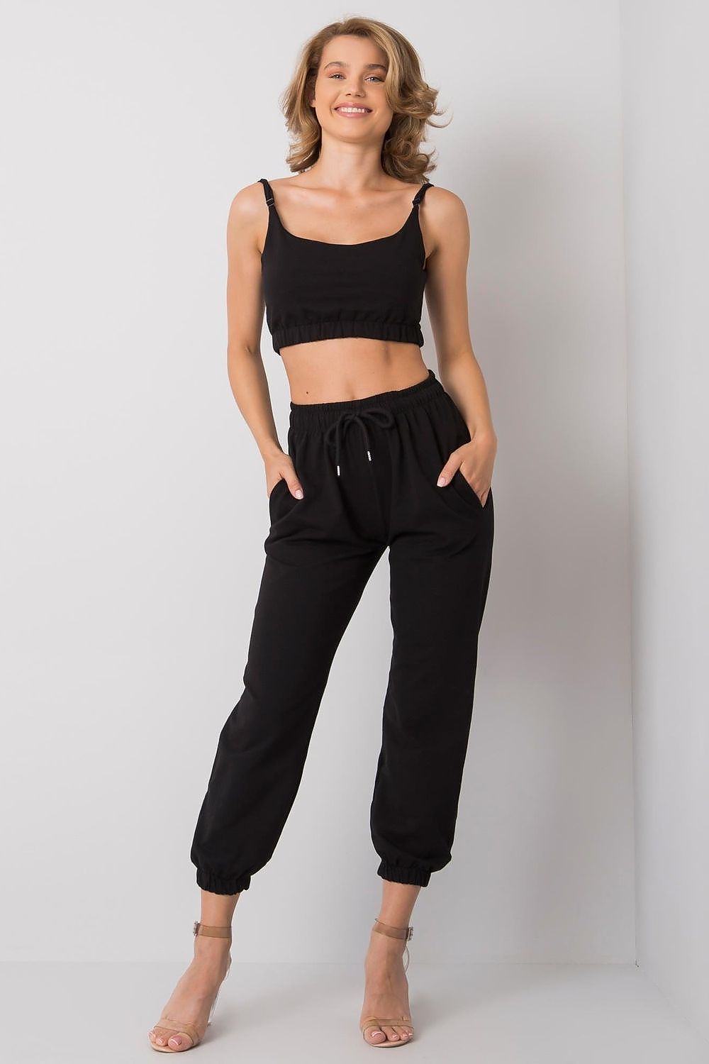 Ex Moda Women's Sports Set featuring an adjustable strap top and elastic waist sweatpants with pockets, model showcases the stylish ensemble, perfect for sporty elegance.