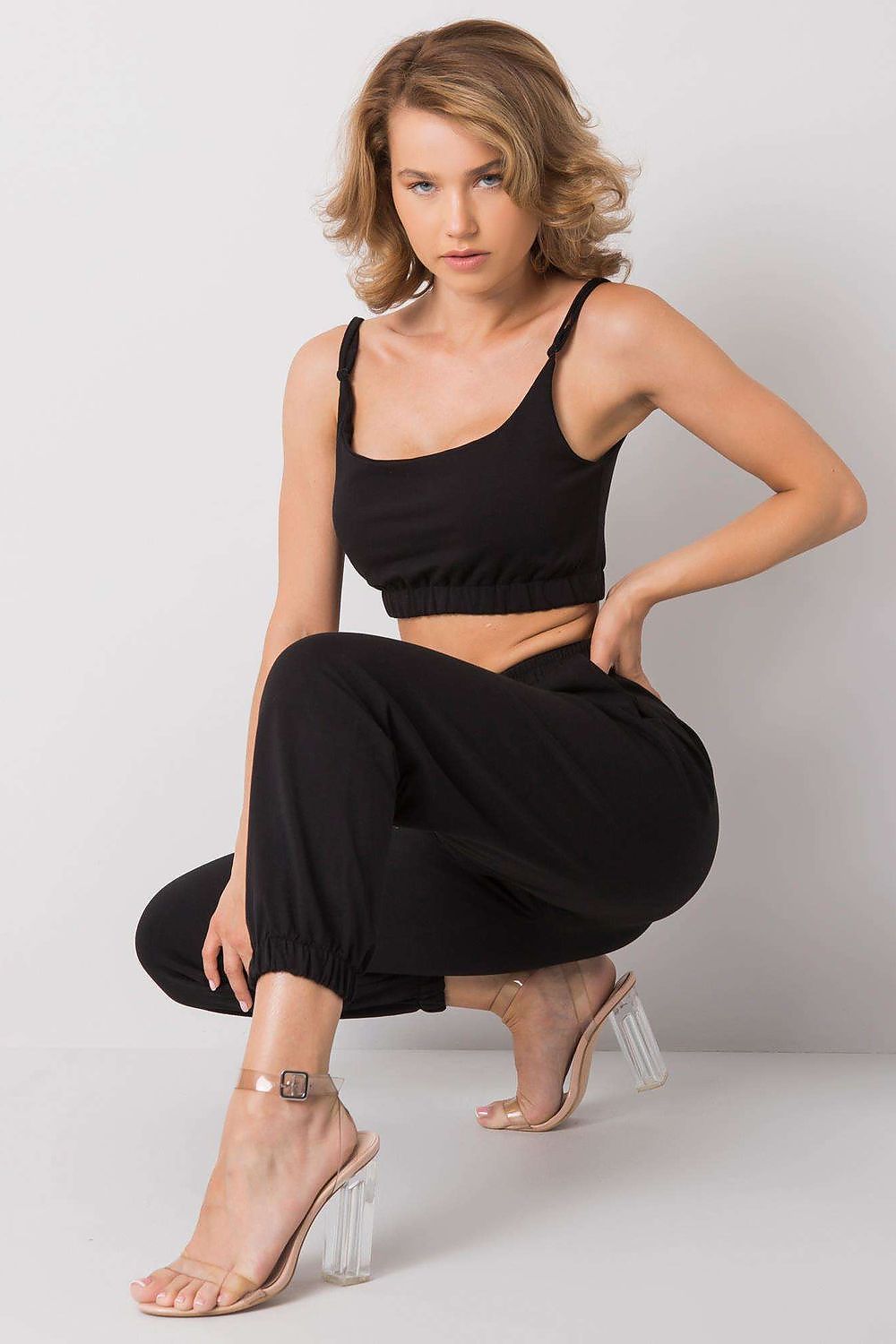 Ex Moda Women's Sports Set, model seated in an adjustable strap top and elastic waist sweatpants with pockets, epitomising chic comfort and versatility.