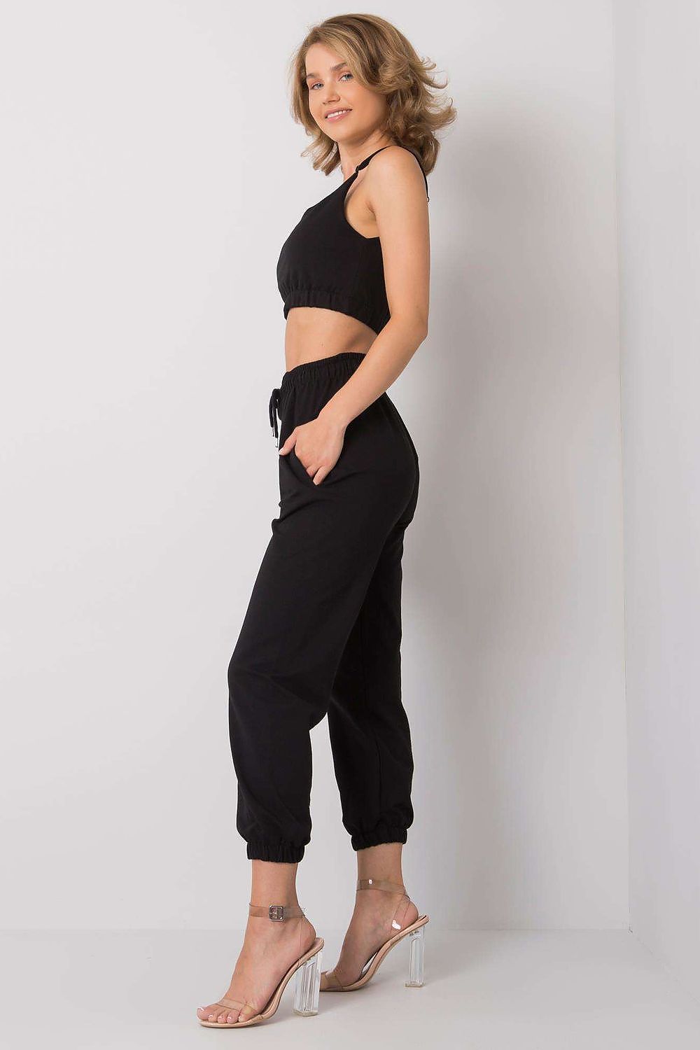 Ex Moda Women's Sports Set presented on model in profile, adjustable strap top and elastic waist sweatpants with pockets highlight a sophisticated sporty look.
