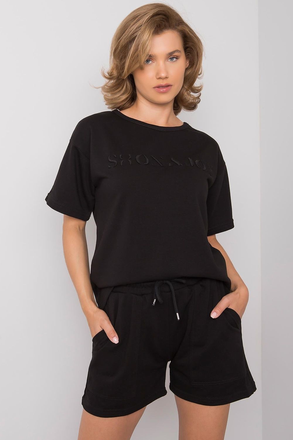 Luxury Summer Set: Short Sleeve Blouse & Shorts in 70% Cotton, featuring a stylish black design, side pockets, and an adjustable waist, modeled by a woman with blonde hair.
