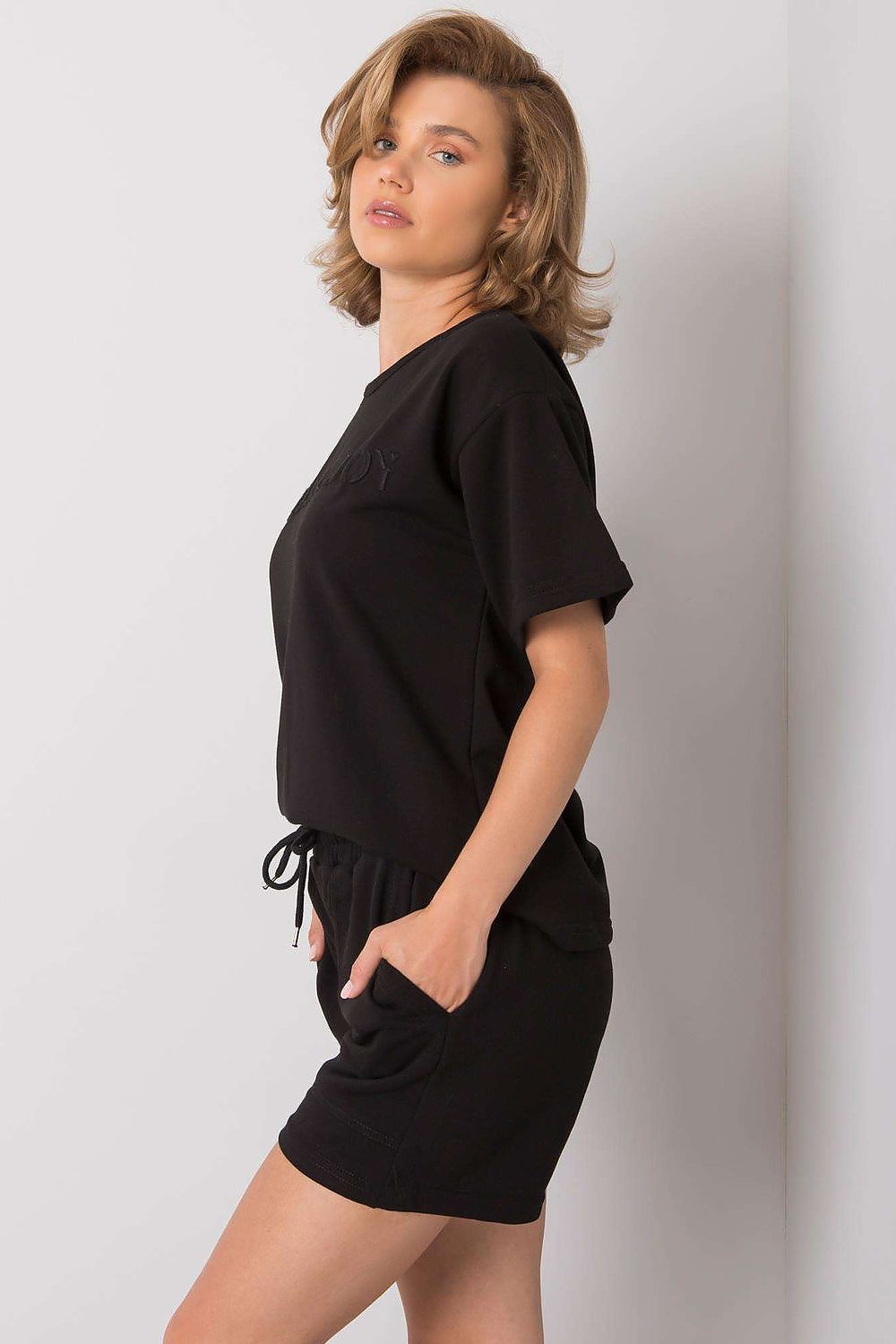 Luxury Summer Set: Short Sleeve Blouse & Shorts in 70% Cotton, featuring a refined black outfit with an adjustable waist and side pockets, styled on a woman with a sophisticated look.
