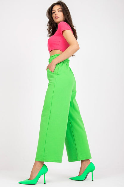 Luxury High-Waist Tracksuit Trousers with Wide Legs and Slip-On Pockets in Cotton-Spandex Blend, model showcasing vibrant green trousers styled with a pink crop top and green heels, side profile view.