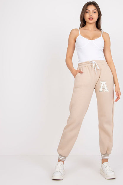 Fashionable model wearing Ex Moda Women's Cotton-Blend Sweatpants with Elastic Waistband and Slip-On Pockets, standing confidently in a light-coloured environment, paired with a simple yet chic white top.