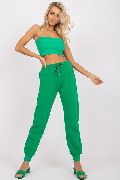 Ex Moda Women's Tracksuit Trousers in vibrant green, featuring an elastic waist and slip-on pockets, styled with a matching crop top and heels for an elegant athleisure look.
