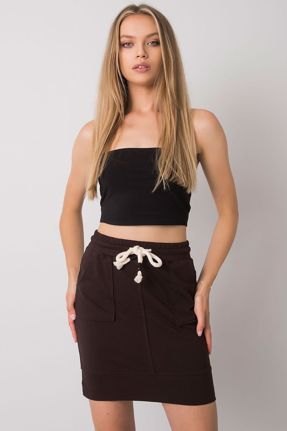 Elegant Mini Skirt with Elastic Waistband and Pockets - Cotton Blend for Comfortable Fit, showcased on a model with long hair wearing a black crop top, featuring a stylish brown mini skirt.