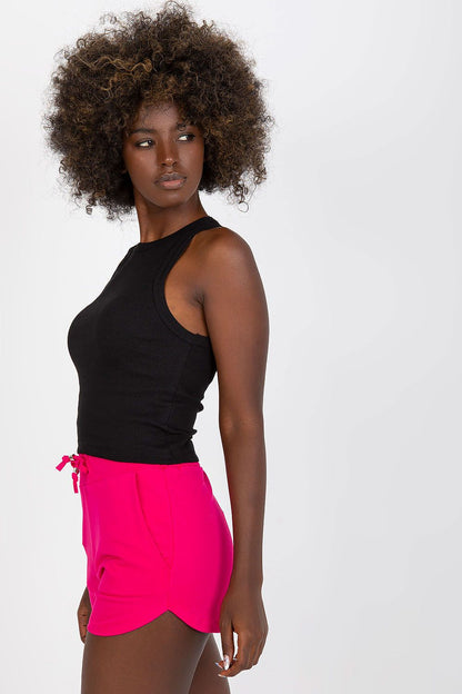 BFG Classic Ribbed T-Shirt - Black, model posing in profile with a round neckline, elegantly paired with pink shorts, highlighting a fashionable ensemble.