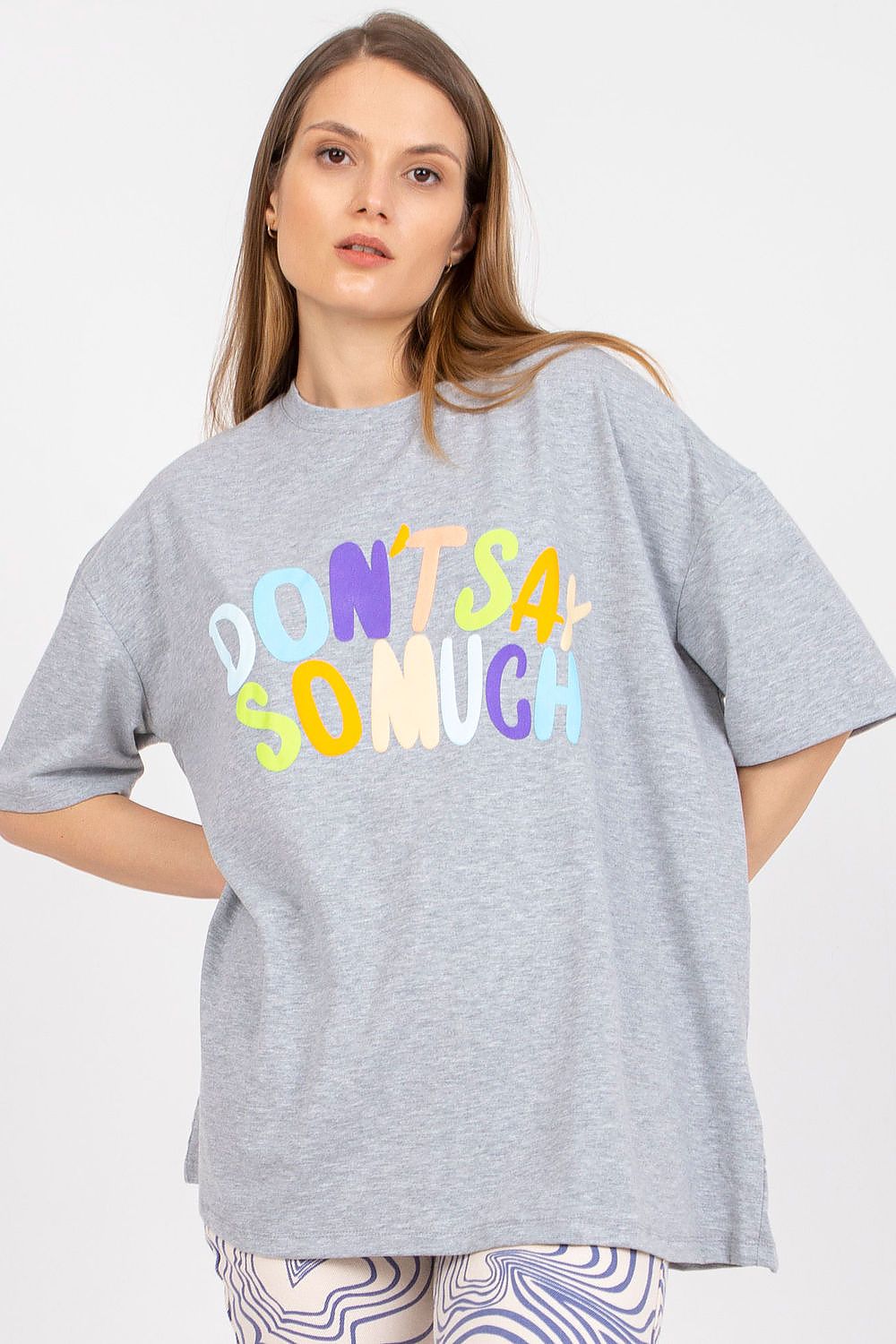 Stylish Loose-Fit Ladies' T-Shirt with Decorative Front Wording - Cotton & Spandex Blend, featuring a model in a grey t-shirt with captivating decorative wording, elegantly styled with patterned trousers.