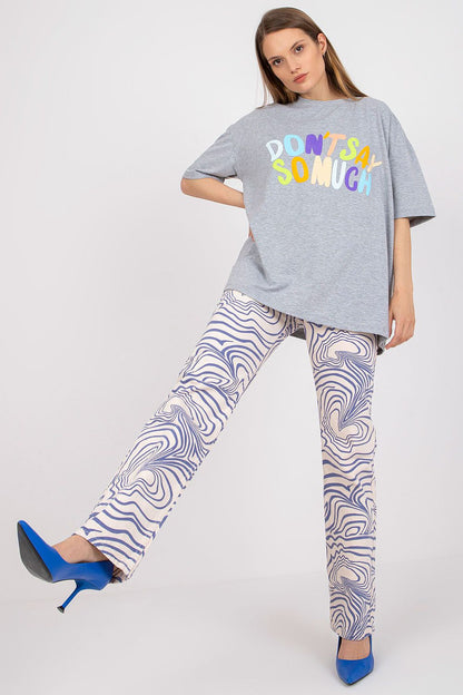 Chic Stylish Loose-Fit Ladies' T-Shirt with Decorative Front Wording, featuring vibrant text, paired with patterned trousers, perfect for a fashionable casual look.