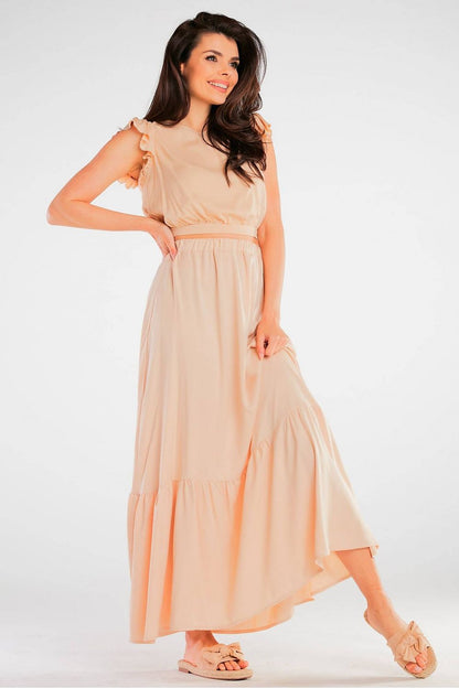 Model wearing the Elegant Airy Viscose Blouse with Back Tie and Charming Frills at Sleeves in a flowing beige maxi dress, highlighting its graceful silhouette and airy fabric.
