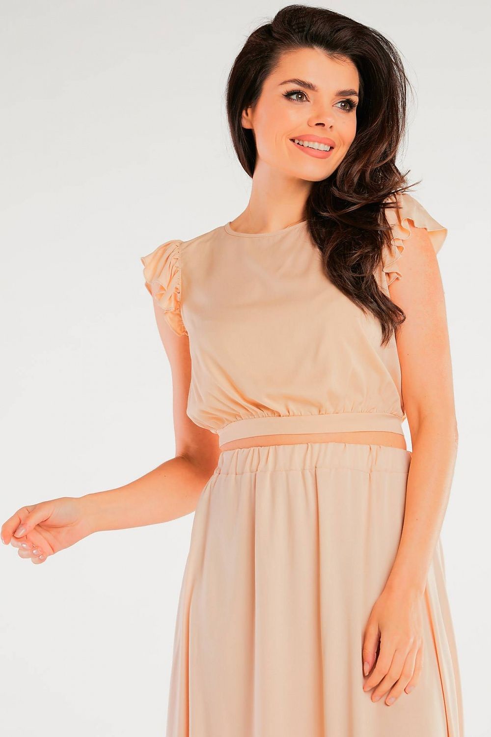 Model smiling while wearing the Elegant Airy Viscose Blouse with Back Tie and Charming Frills at Sleeves in a soft beige colour, perfectly capturing an essence of luxurious comfort.