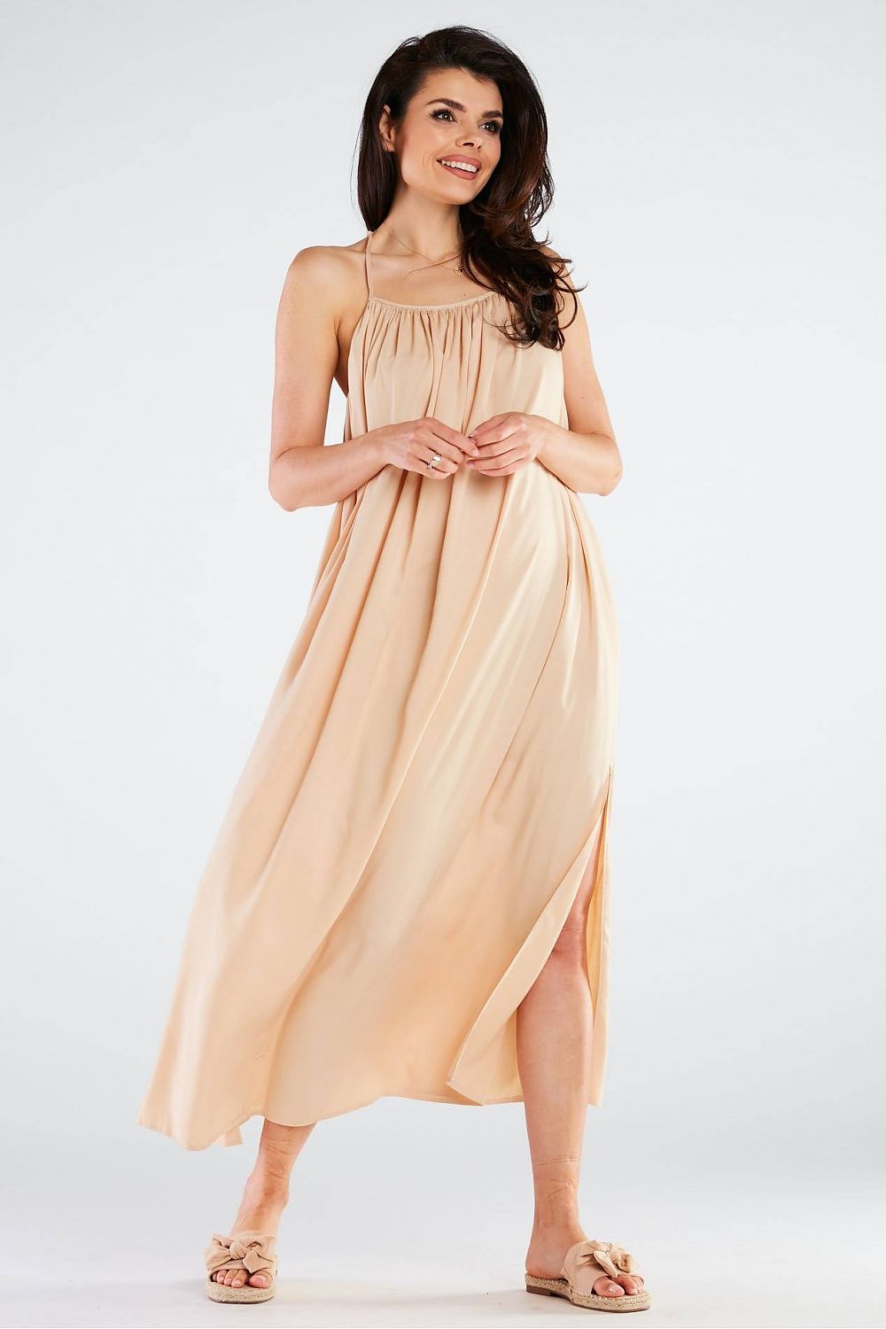 Elegant Maxi Dress by Awama displayed in a soft nude shade, emphasising the luxurious viscose material and chic side slit, ideal for elegant occasions.