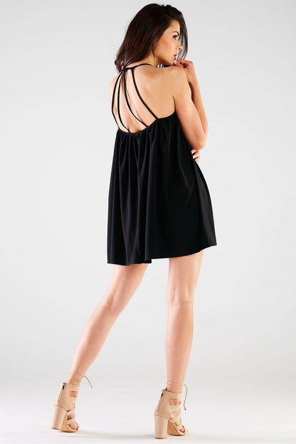 Dramatic back view of the Awama Loose Mini Dress in black, showcasing elegant straps and a trapeze cut that creates an exquisite silhouette.