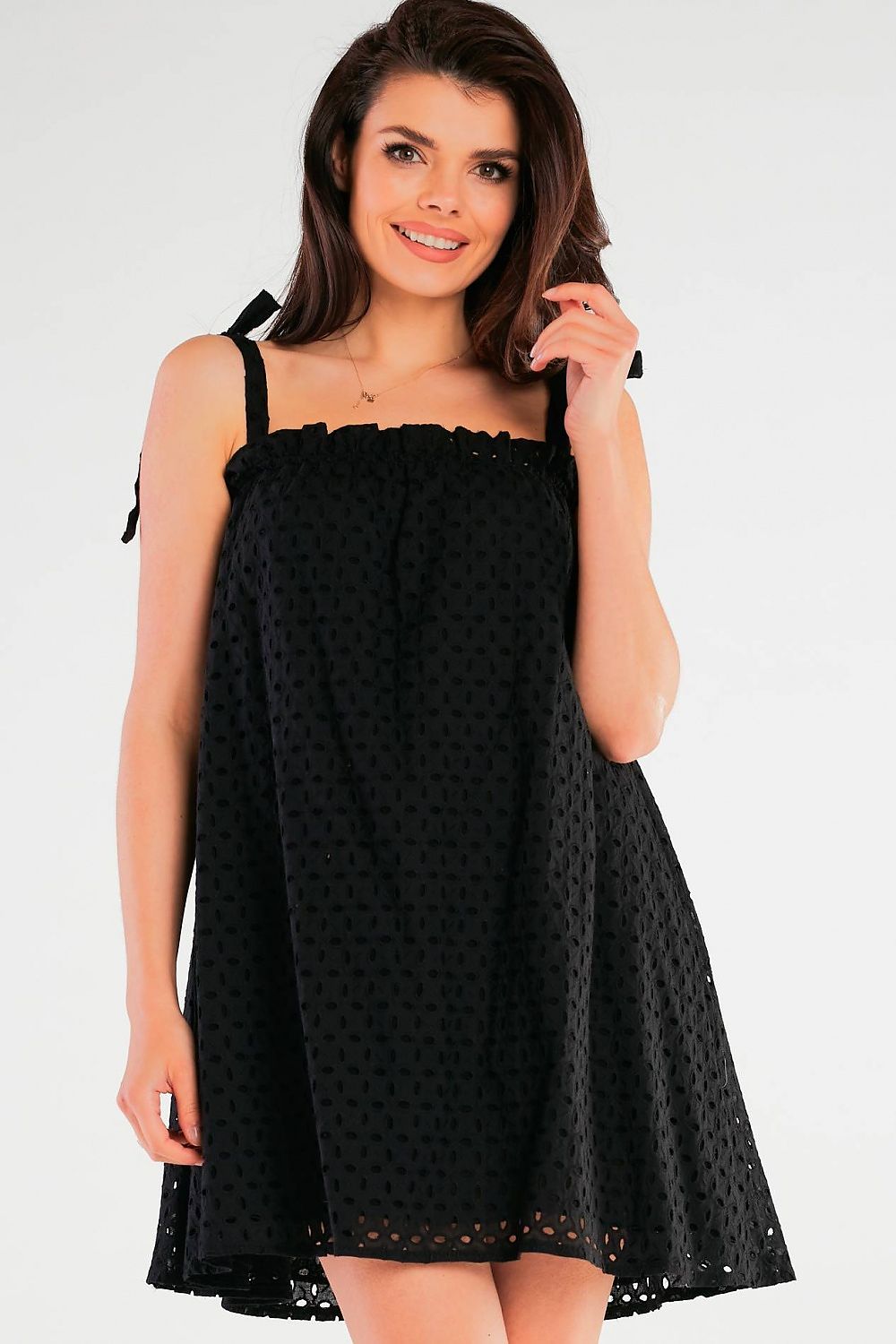 Elegant Flared Cotton Daydress with Tied Straps and Pleated Neckline by Awama - Made in Poland, model showcasing the black version of the dress with a charming smile.