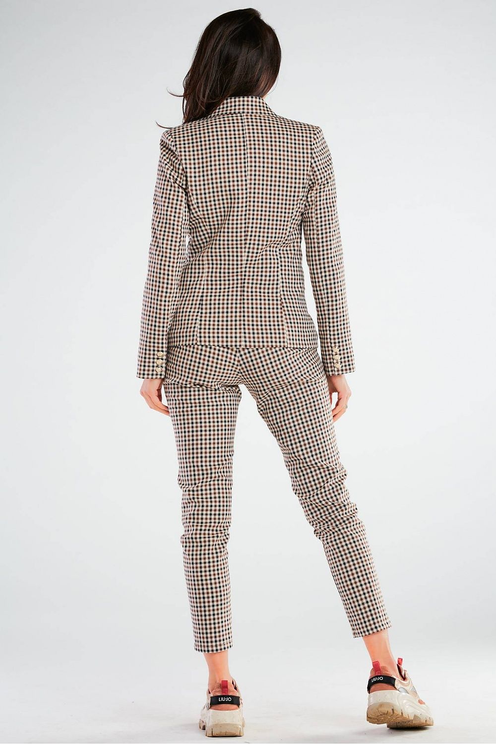 Rear view of the model wearing Elegant Women's Fitted Trousers with Pockets in Unique Patterns by Awama, highlighting the luxurious tailoring and unique design.