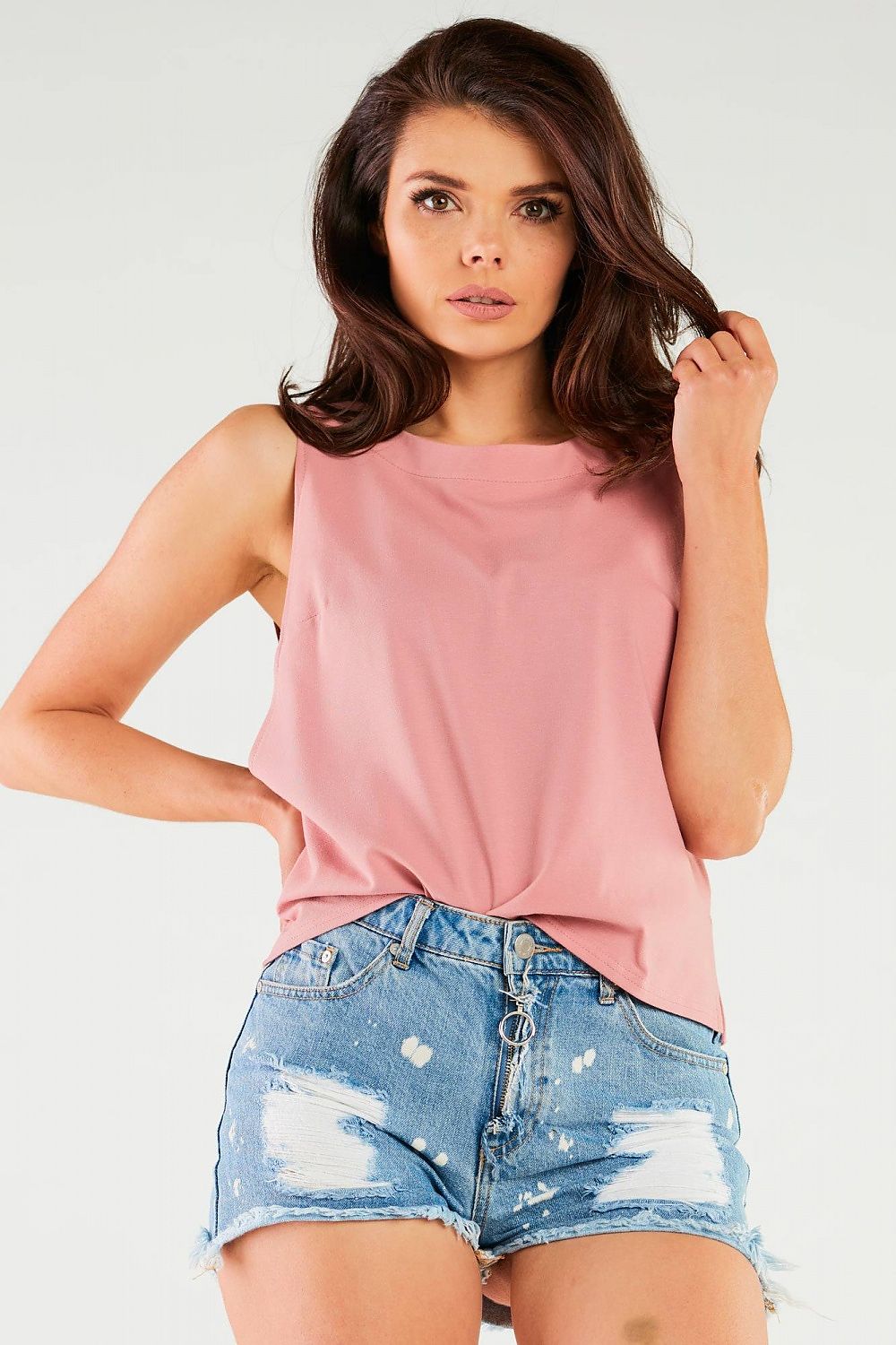 Woman in a pink Luxury Cotton Blouse by Infinite You, complemented by denim shorts, perfect for a leisurely day out.