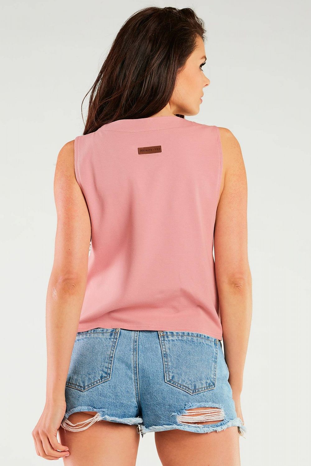 Luxury Cotton Blouse by Infinite You, showcasing a soft pastel pink back view, paired with stylish denim shorts for a fashionable summer look.