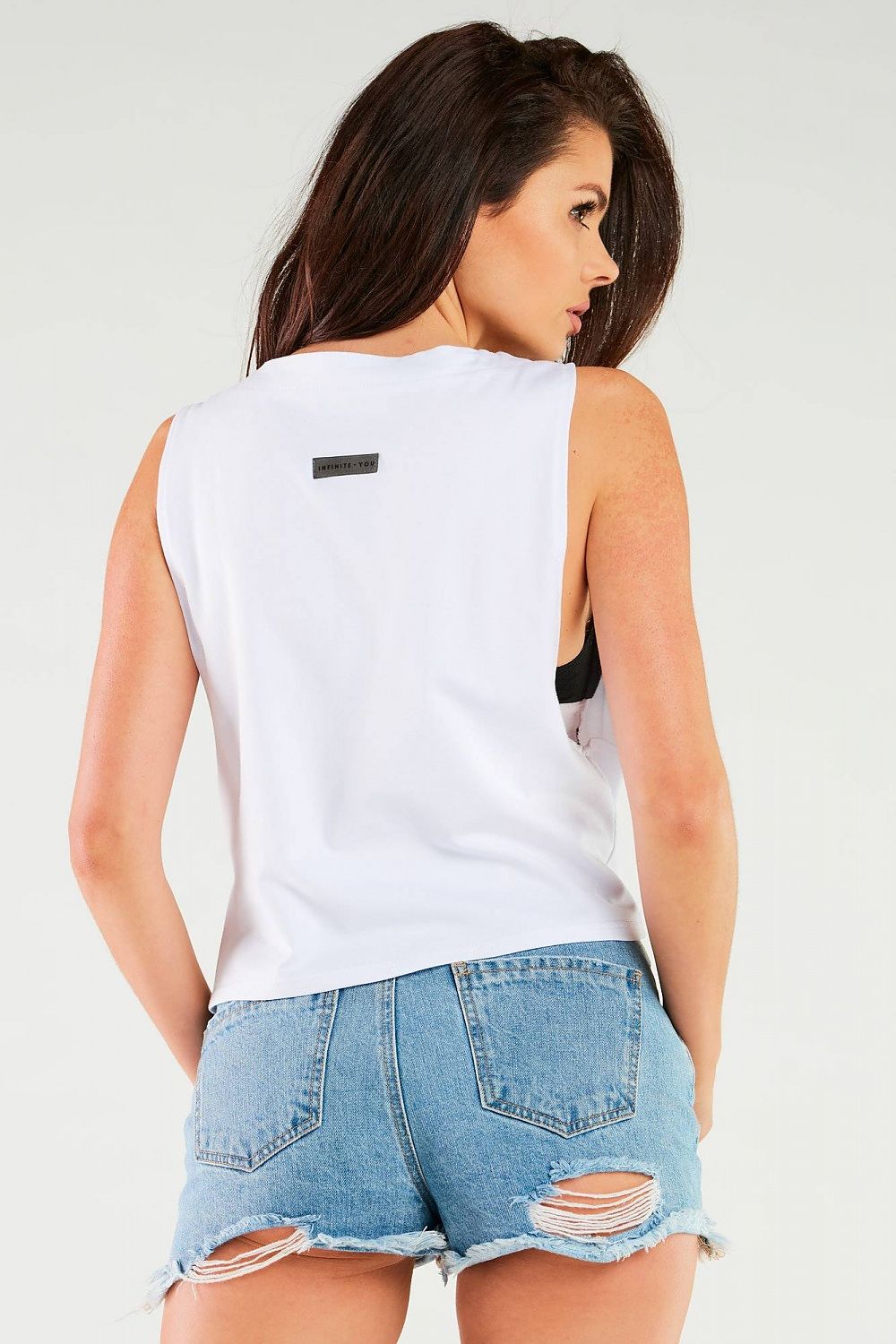 Luxury Cotton Blouse by Infinite You - Soft & Comfortable. Back view of model in white cotton blouse paired with ripped denim shorts.