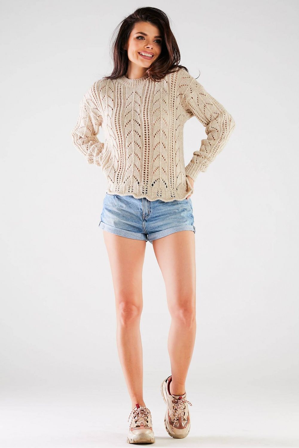 Luxury Ladies Sweater by Awama in a neutral tone, featuring a long sleeve design with a stylish ribbed finish, showcased on a model wearing denim shorts and sneakers.