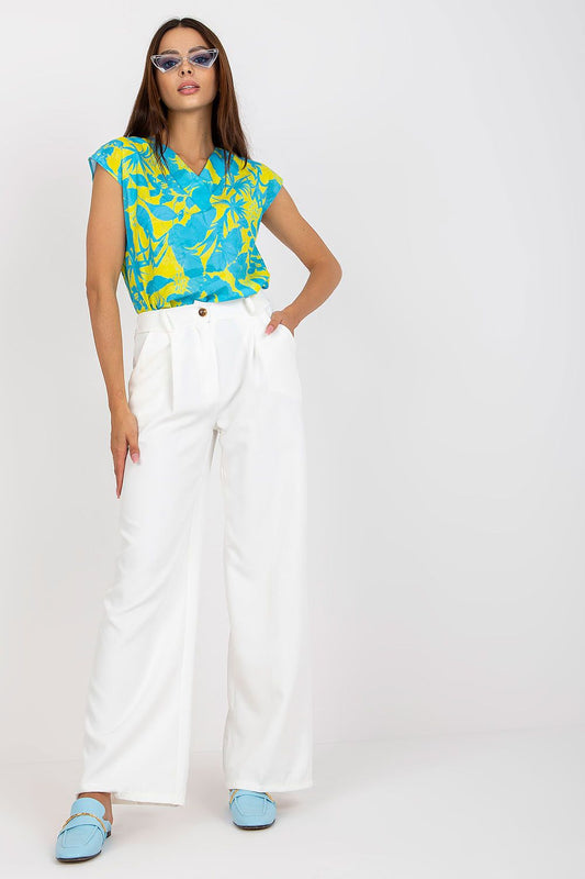 Luxury Women’s Italy Moda Trousers showcased on a model wearing high-rise fabric pants with zip and button fastening, paired with a vibrant blue and yellow floral top, exuding elegance and sophistication.