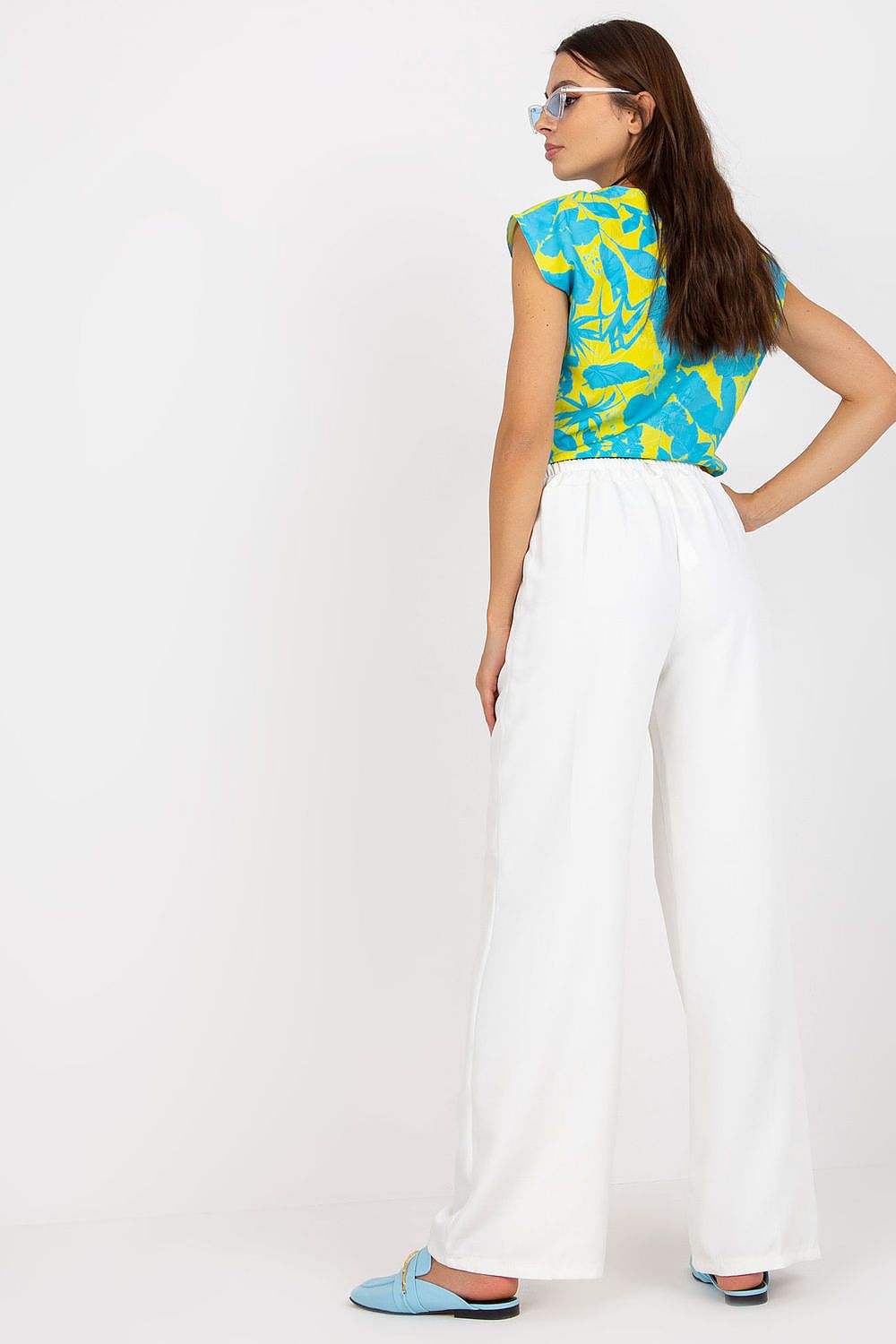 Back view of the Luxury Women’s Italy Moda Trousers - High Rise Fabric Pants with Zip and Button Fastening, paired with a vibrant patterned top, highlighting the comfortable and elegant design.