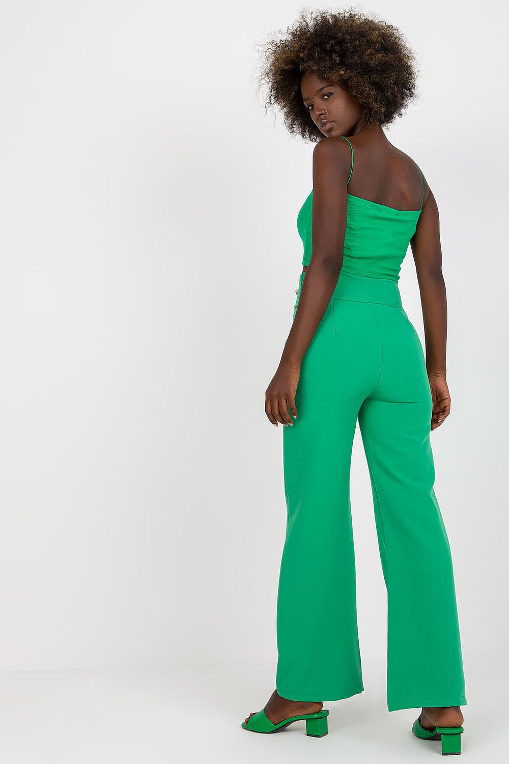 Elegantly styled high-waisted trousers with decorative buttons from Italy Moda, showcased on a model in a chic green outfit.