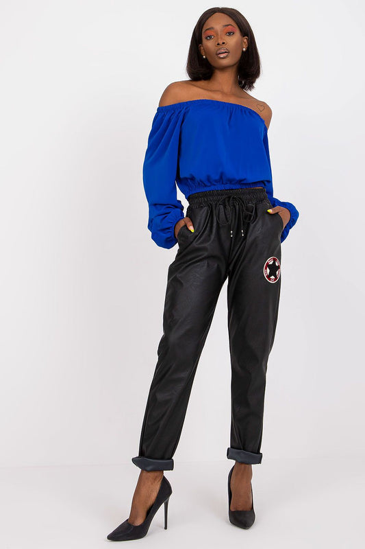 Elegant model showcasing Luxury Women's Ecological Leather Trousers with Elastic Waistband by Italy Moda, styled with an off-shoulder blue blouse in a chic pose.