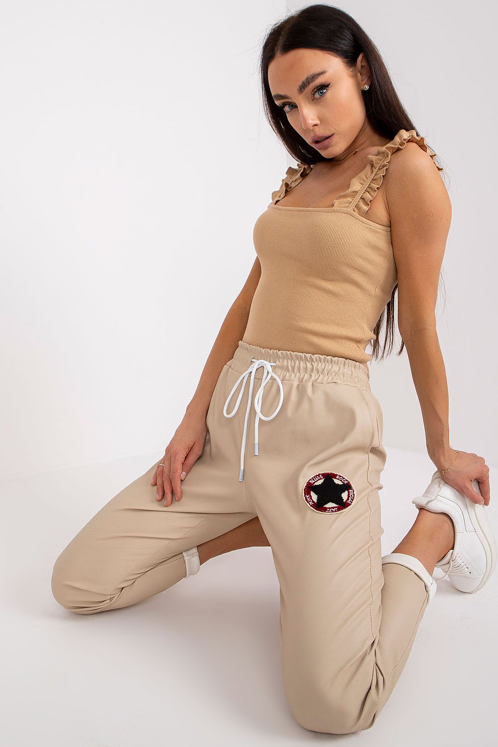 Close-up of Luxury Women's Ecological Leather Trousers With Elastic Waistband - Italy Moda, highlighting the elegant design and unique patch detail, styled with a beige top.